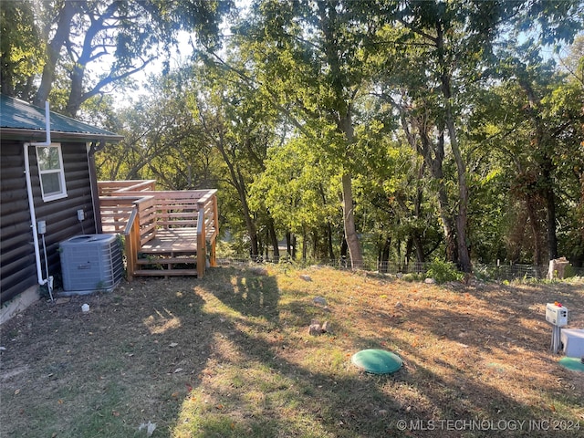 view of yard with central AC and a wooden deck