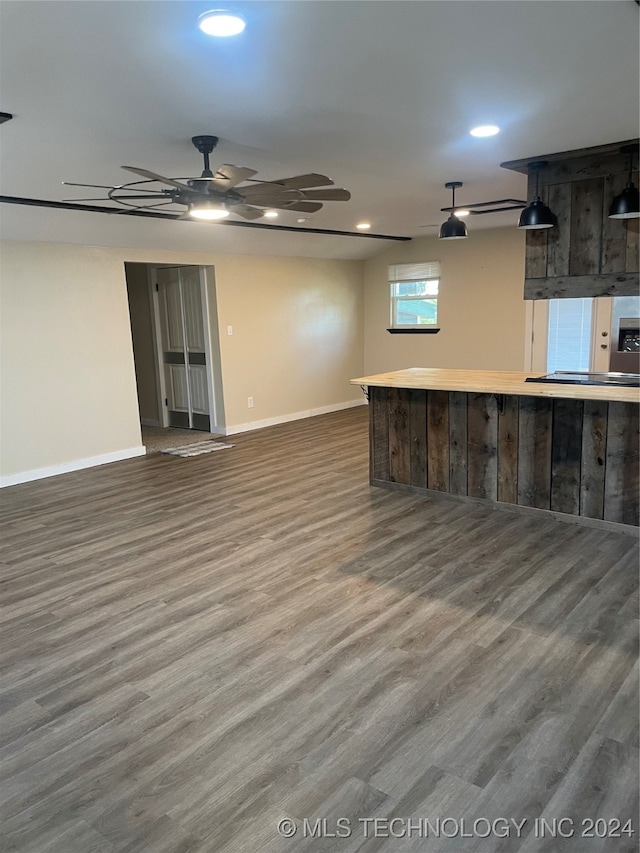 basement featuring ceiling fan and dark hardwood / wood-style floors