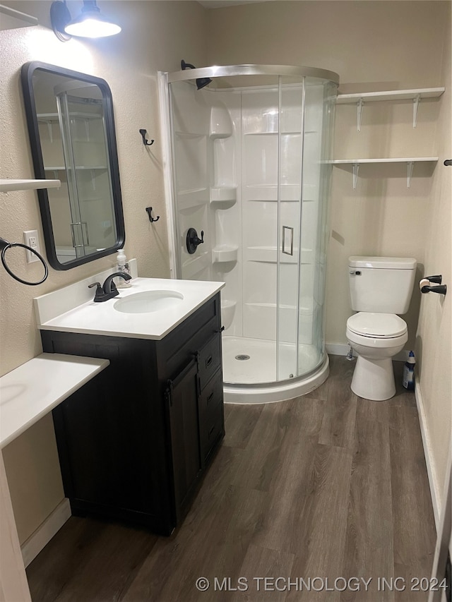 bathroom with walk in shower, vanity, hardwood / wood-style flooring, and toilet