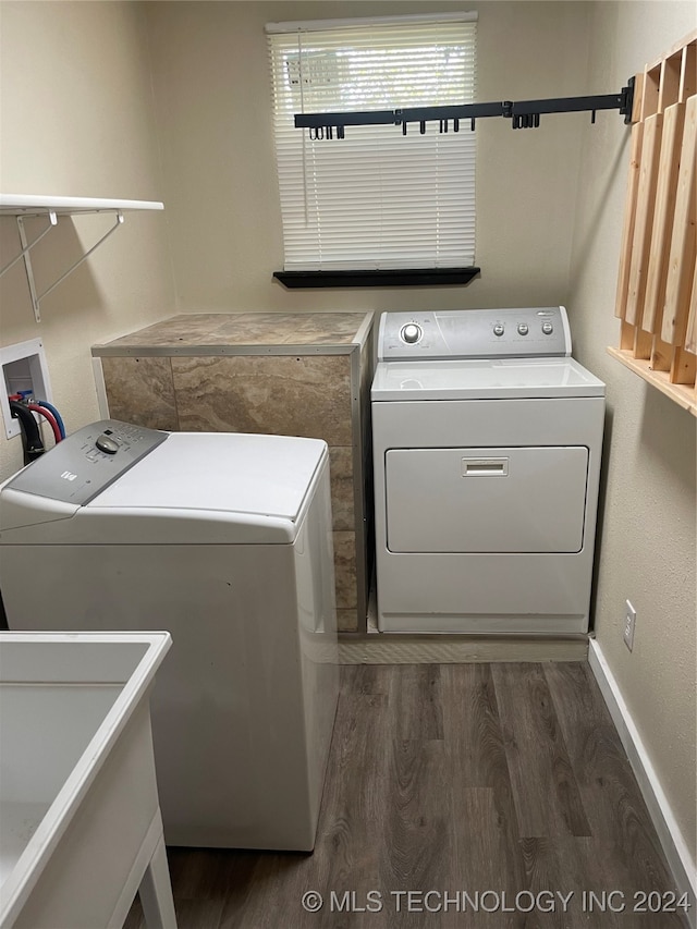 washroom with separate washer and dryer, dark hardwood / wood-style floors, and sink