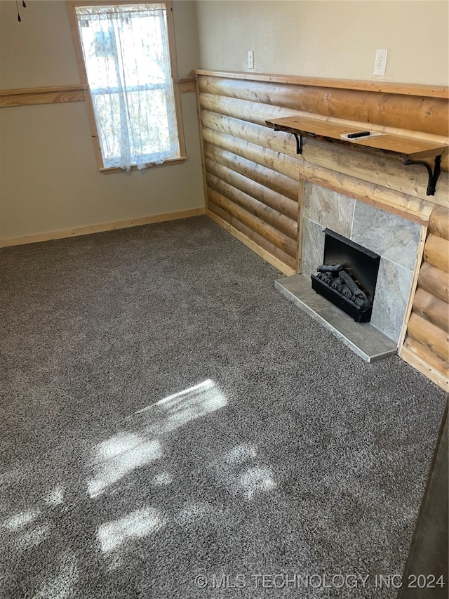 unfurnished living room featuring log walls, carpet, and a fireplace