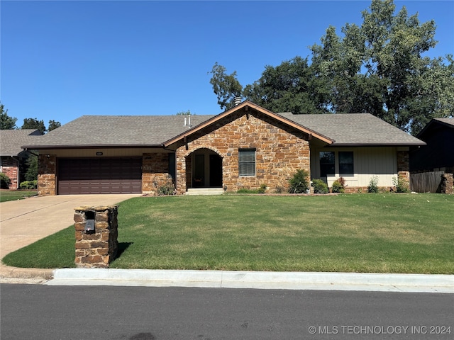 ranch-style home featuring a front lawn and a garage