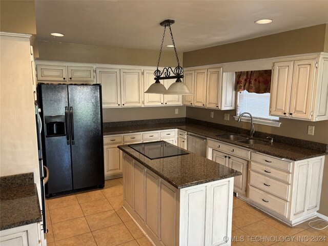 kitchen featuring dark stone counters, sink, a kitchen island, black appliances, and decorative light fixtures