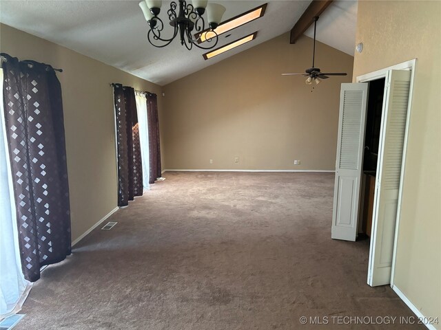 spare room featuring ceiling fan with notable chandelier, lofted ceiling with beams, and dark carpet