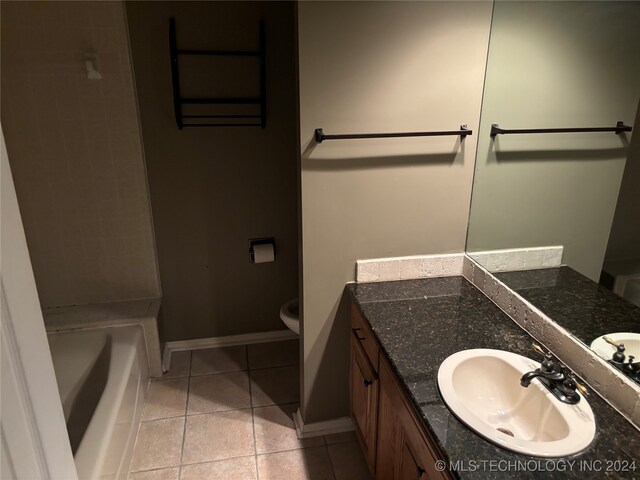 bathroom with vanity, toilet, a washtub, and tile patterned floors