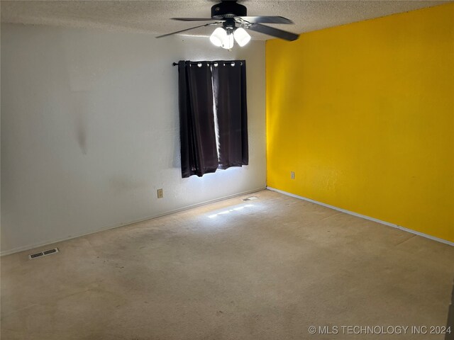 carpeted empty room with a textured ceiling and ceiling fan