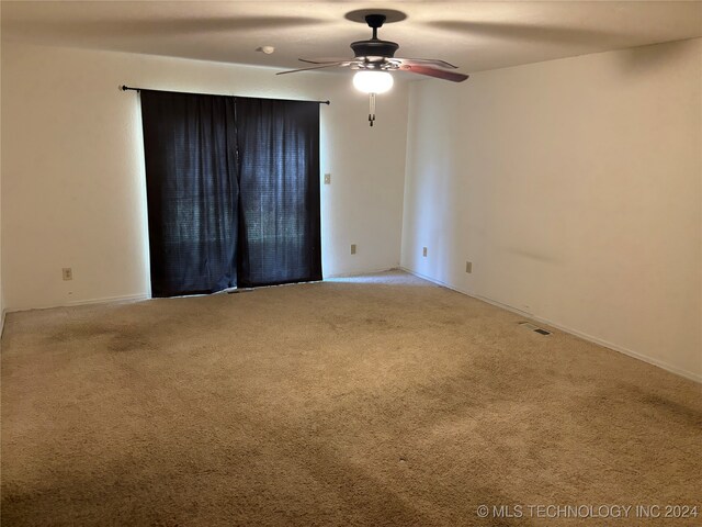 empty room featuring ceiling fan and carpet floors