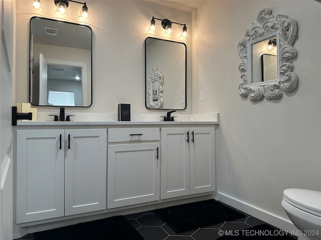 bathroom featuring vanity, toilet, and tile patterned floors