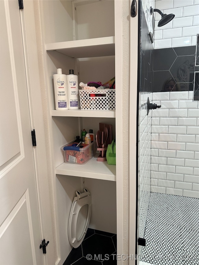 bathroom with tile patterned flooring and tiled shower