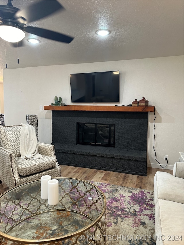 living room with wood-type flooring, a textured ceiling, and ceiling fan