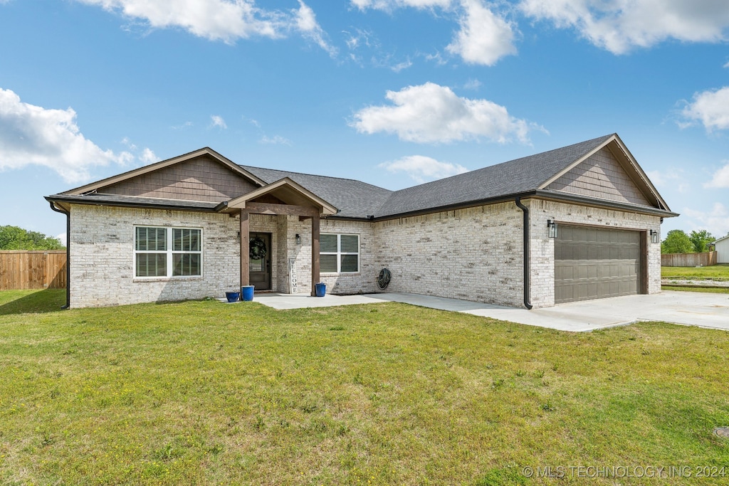 view of front of home with a garage and a front lawn