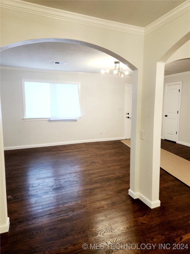 empty room featuring ornamental molding and dark hardwood / wood-style flooring