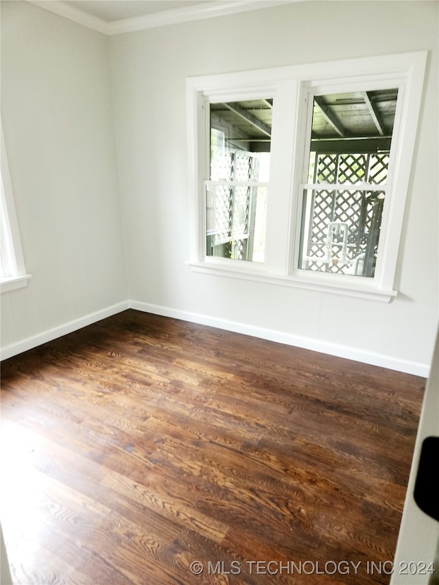 spare room with crown molding and dark hardwood / wood-style flooring