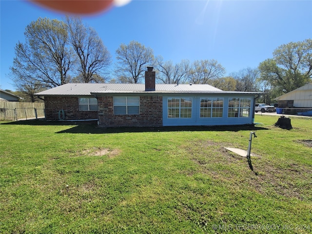 rear view of house featuring a yard