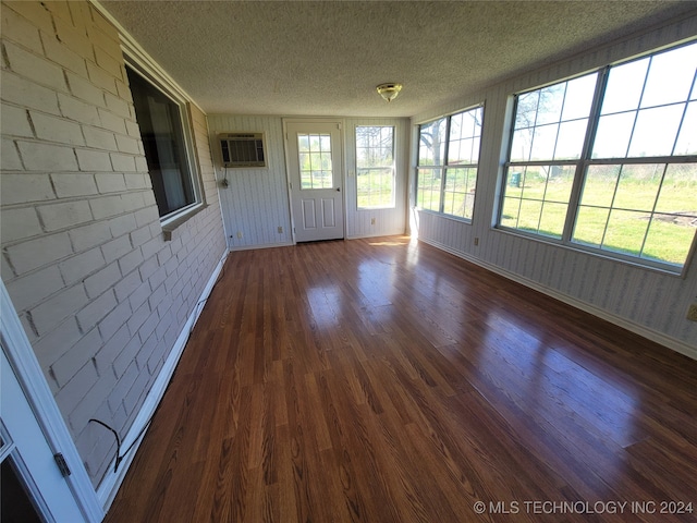 unfurnished sunroom with a wall mounted air conditioner