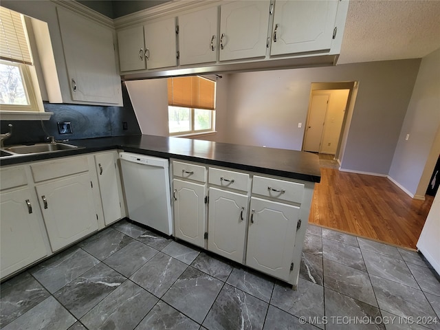 kitchen with white cabinets, white dishwasher, kitchen peninsula, and a textured ceiling