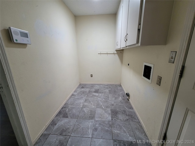 washroom with hookup for an electric dryer and cabinets