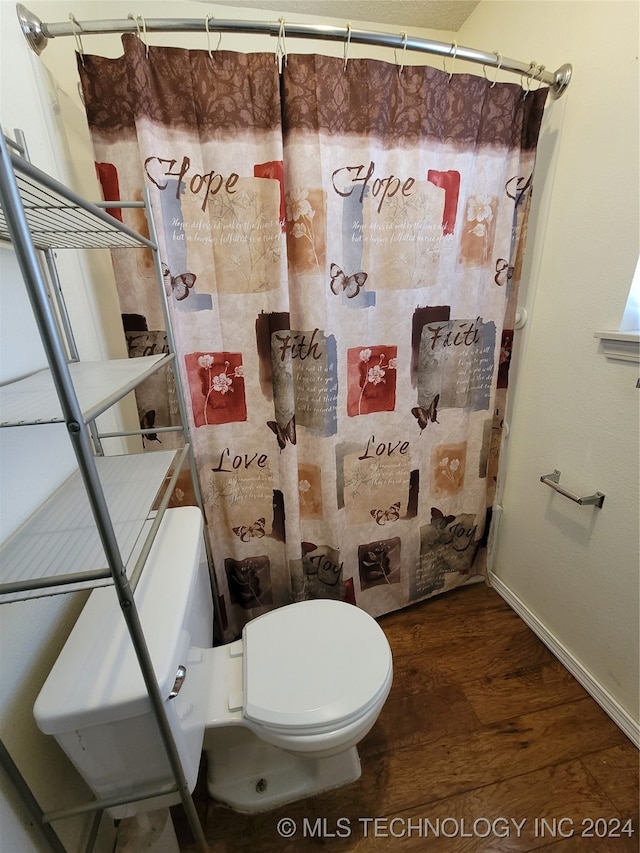 bathroom featuring a shower with curtain, hardwood / wood-style floors, and toilet