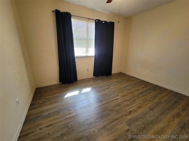 unfurnished room with ceiling fan and dark hardwood / wood-style flooring