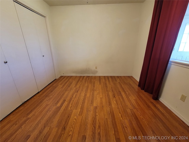 unfurnished bedroom featuring hardwood / wood-style floors and a closet