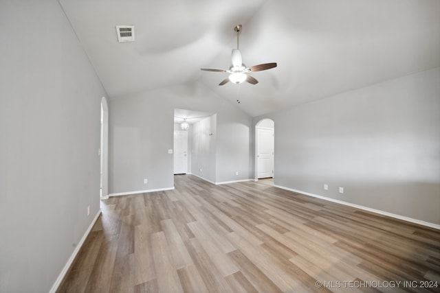 spare room with ceiling fan, light wood-type flooring, and vaulted ceiling