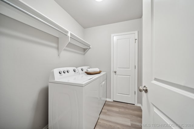 washroom featuring washing machine and dryer and light hardwood / wood-style floors