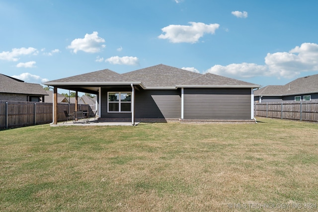 rear view of house featuring a patio area and a lawn