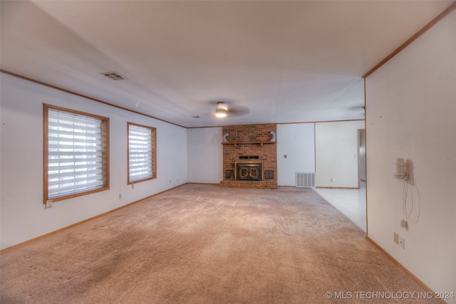 unfurnished living room featuring light carpet, a wood stove, and ceiling fan