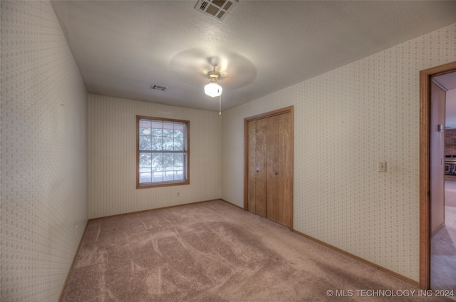 unfurnished bedroom featuring a closet, ceiling fan, and carpet floors