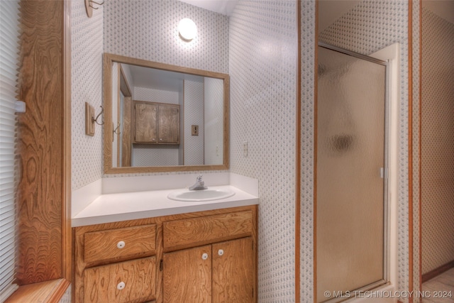 bathroom featuring vanity and a shower with door