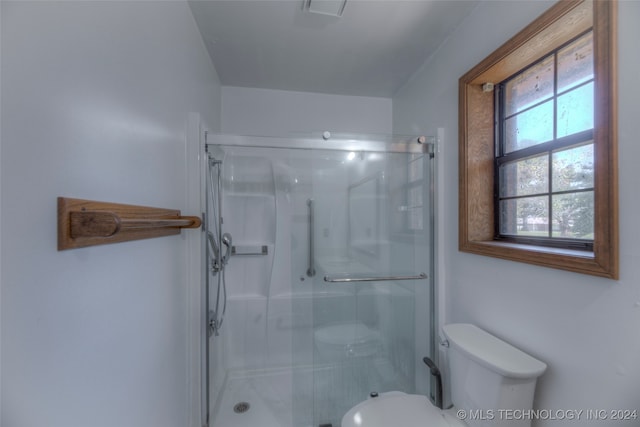 bathroom featuring toilet and an enclosed shower