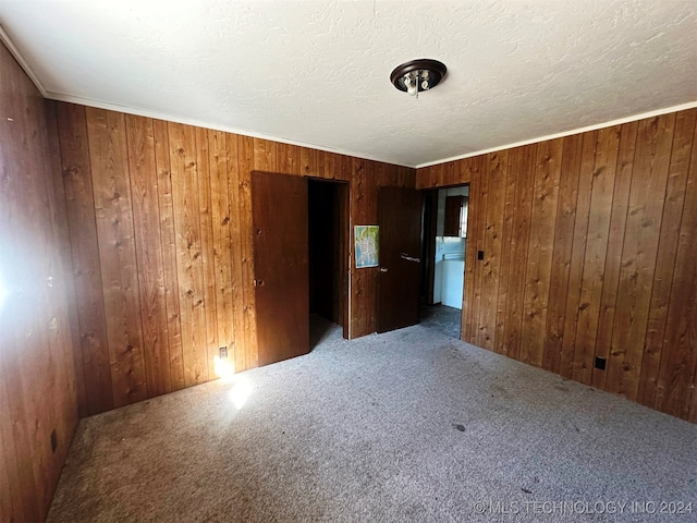 empty room featuring carpet floors and wood walls