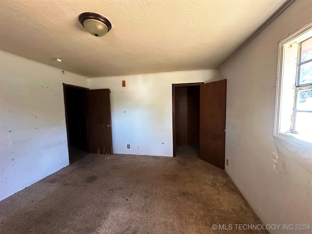 carpeted spare room with a textured ceiling