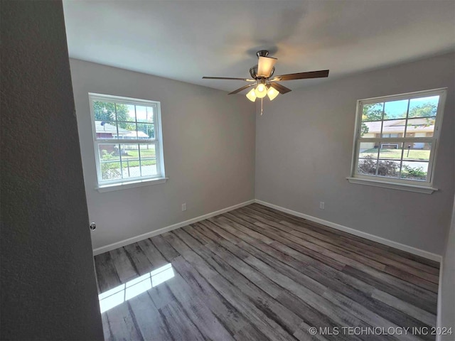 empty room with a healthy amount of sunlight, ceiling fan, and hardwood / wood-style flooring