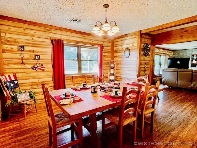 dining area with a textured ceiling, wood-type flooring, a chandelier, and rustic walls