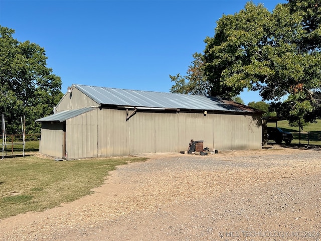 view of side of home featuring a yard and an outbuilding