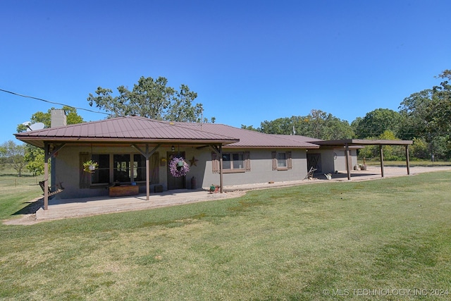 rear view of property with a lawn and a patio area