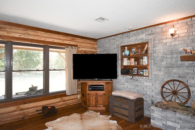 living room featuring a textured ceiling, dark hardwood / wood-style floors, and ornamental molding