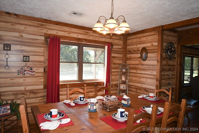 unfurnished dining area with an inviting chandelier, a textured ceiling, and log walls