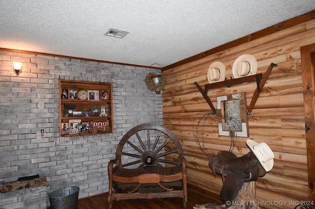 interior space with a textured ceiling and hardwood / wood-style floors