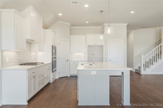 kitchen featuring pendant lighting, a center island with sink, sink, dark hardwood / wood-style floors, and appliances with stainless steel finishes