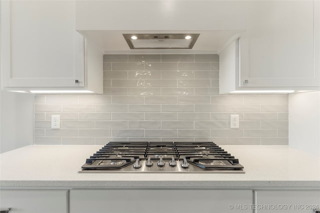 kitchen featuring backsplash, white cabinets, and stainless steel gas cooktop