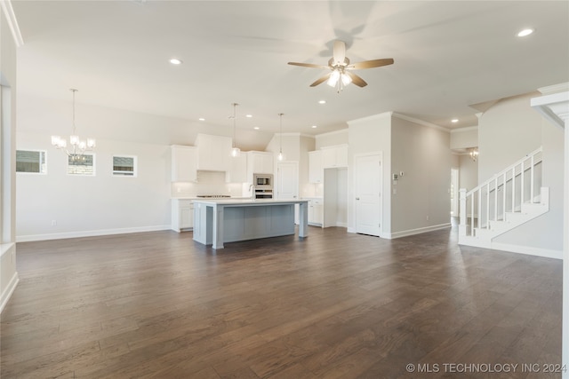 unfurnished living room featuring dark hardwood / wood-style floors, ornamental molding, and ceiling fan with notable chandelier