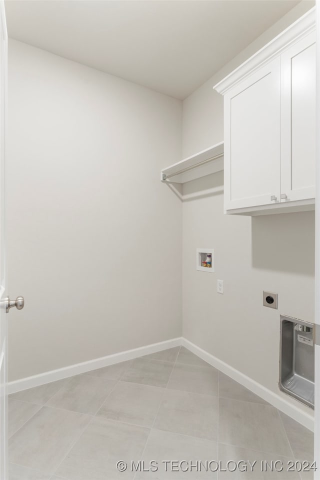 washroom with cabinets, light tile patterned floors, and hookup for a washing machine