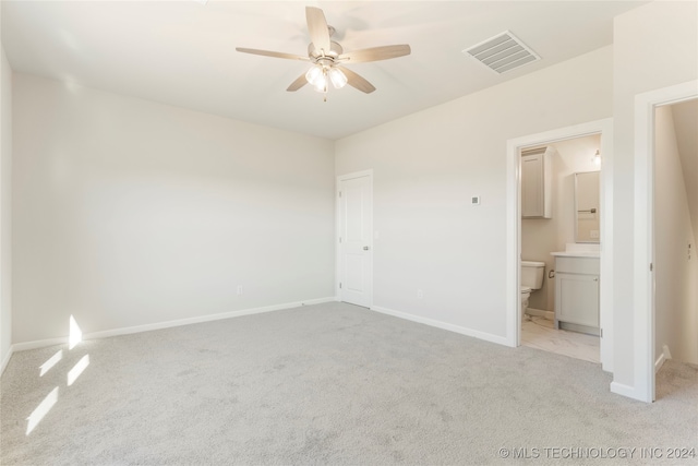 unfurnished bedroom featuring ensuite bathroom, ceiling fan, and light colored carpet