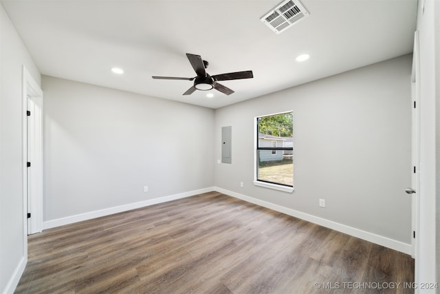 empty room with wood-type flooring, ceiling fan, and electric panel