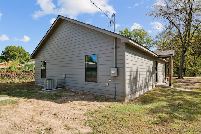 view of side of home featuring a lawn and central air condition unit