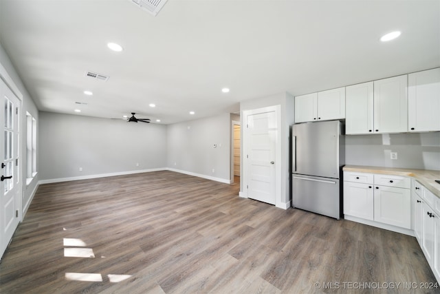 kitchen with ceiling fan, stainless steel fridge, hardwood / wood-style floors, and white cabinetry