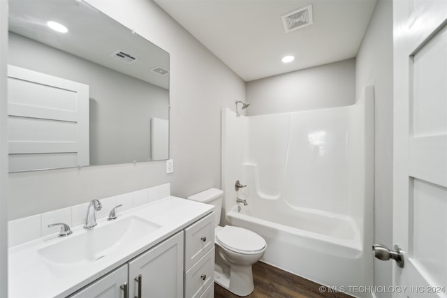 full bathroom with bathtub / shower combination, wood-type flooring, vanity, and toilet