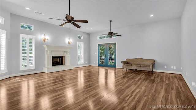 unfurnished living room with hardwood / wood-style floors, ceiling fan, french doors, and a wealth of natural light